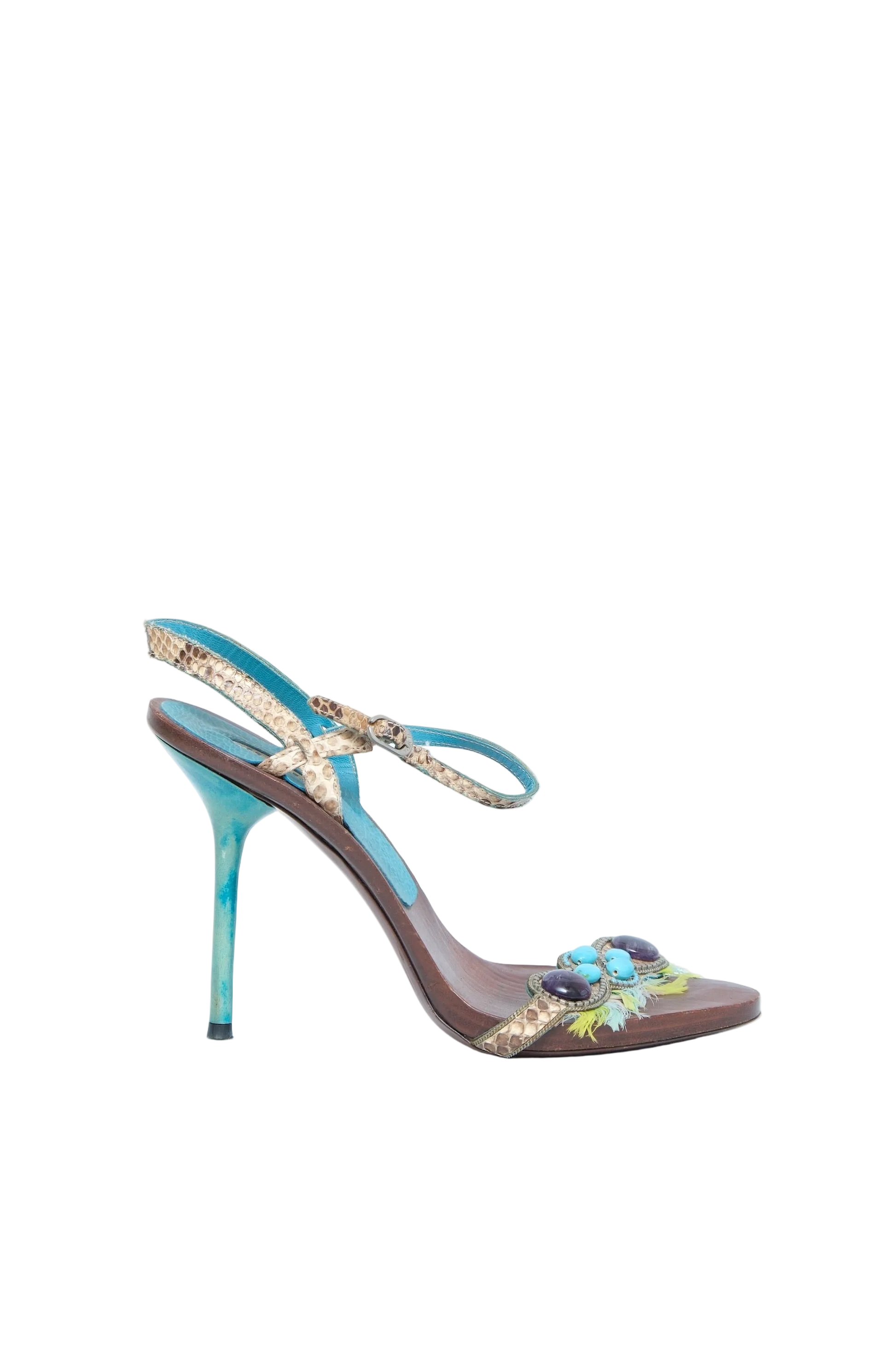 A single women's high-heeled sandal with a brown leather base, turquoise blue straps, and a decorative floral embellishment on the toe strap, shown against a light blue background.