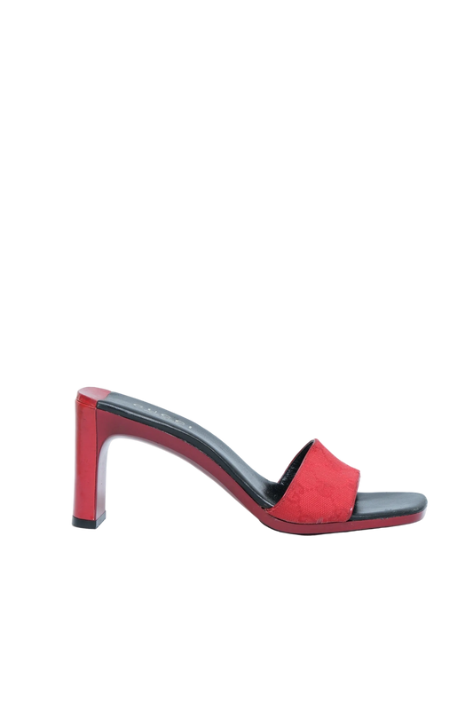 A red open-toe block-heel mule sandal with a black insole and trim, shown in profile against a light gray background.