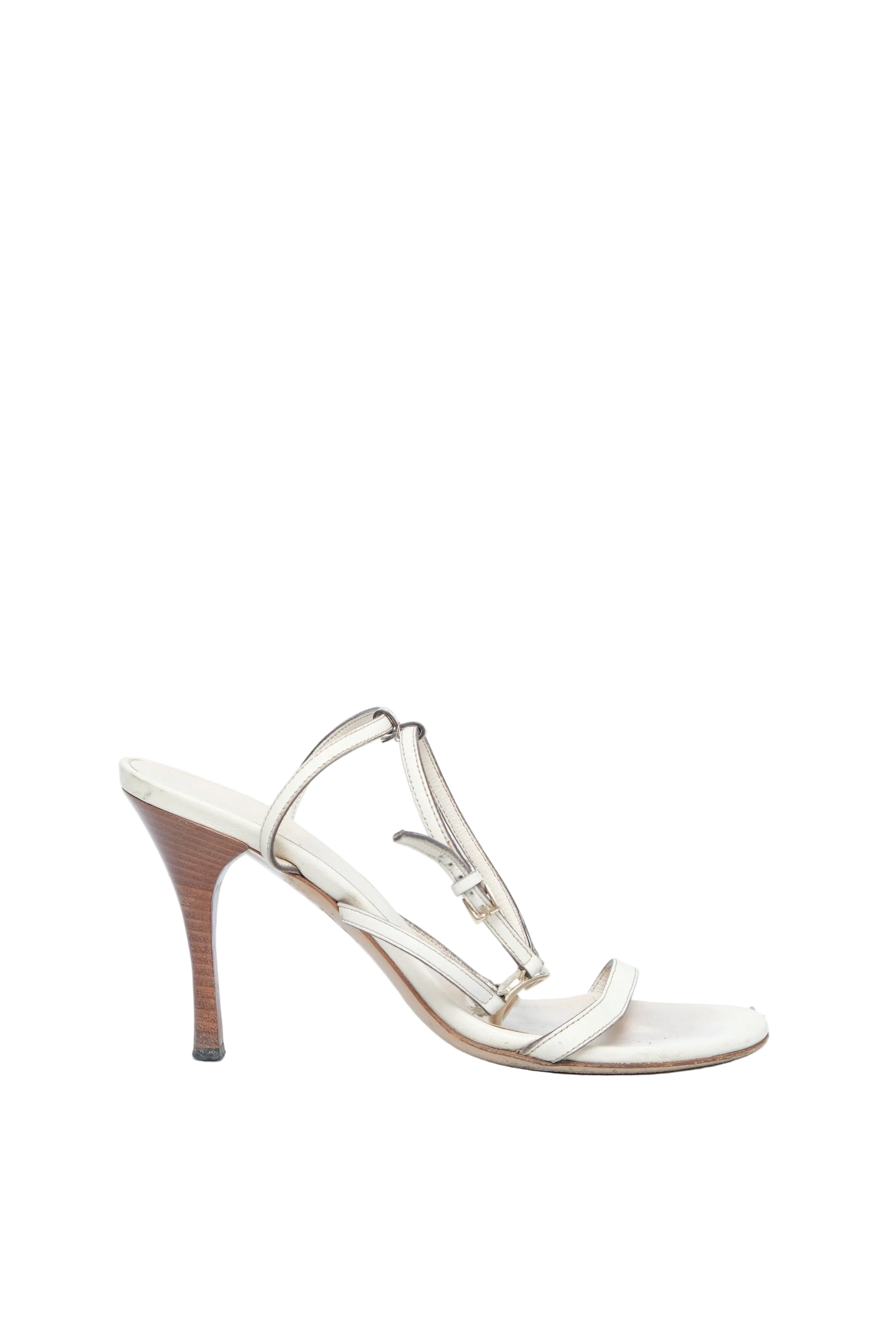 A single women's high-heeled sandal in a light beige or cream tone, featuring thin straps, a T-strap design, and a slim stiletto heel, shown against a solid pale blue background.