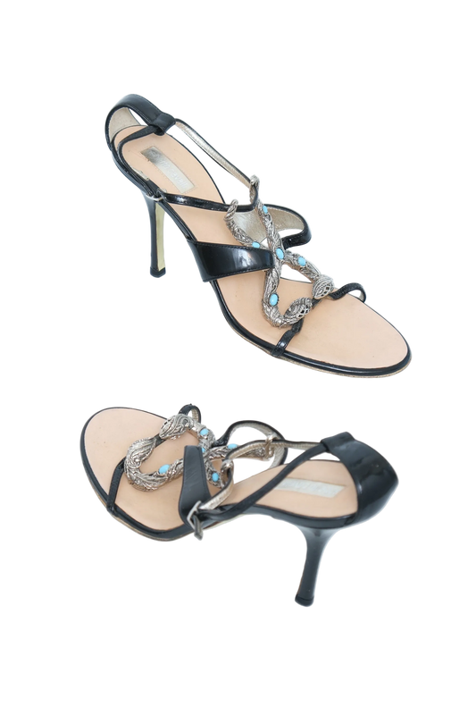 A pair of women's black leather high-heeled sandals with silver chain straps adorned with turquoise blue rhinestones, shown on a plain white background.