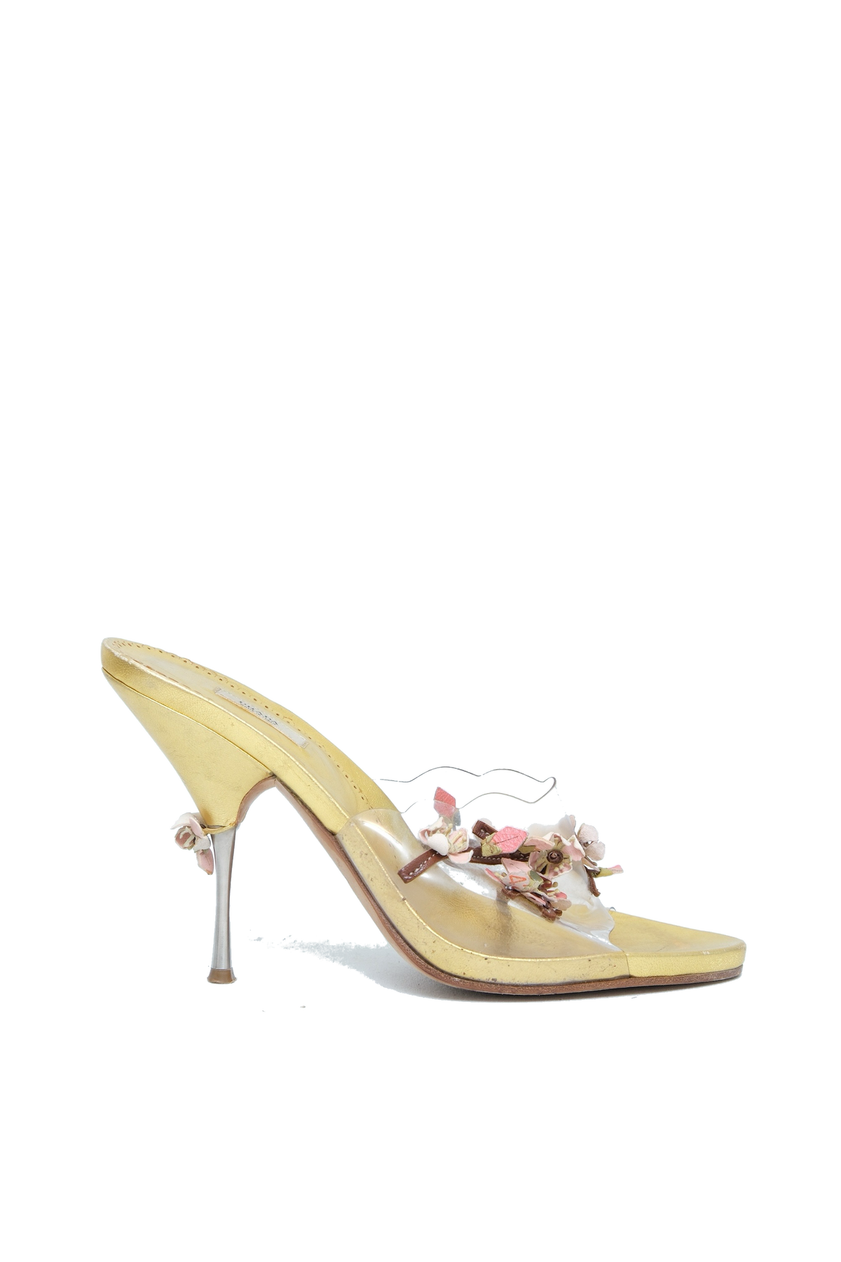 A pale yellow patent leather mule sandal with a pointed toe, a slim stiletto heel, and a decorative floral embellishment on the strap.