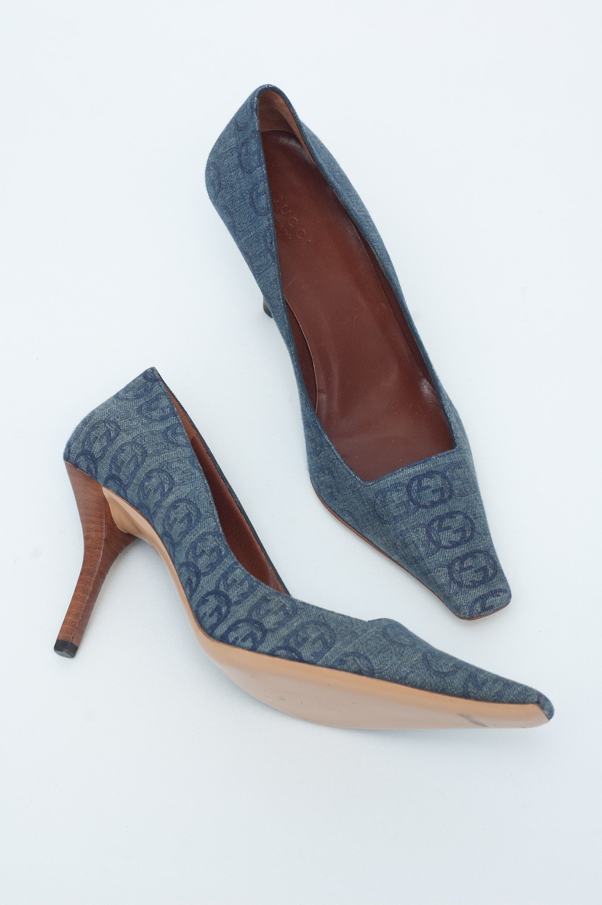 Pair of blue high-heeled shoes with brown soles on a white background
