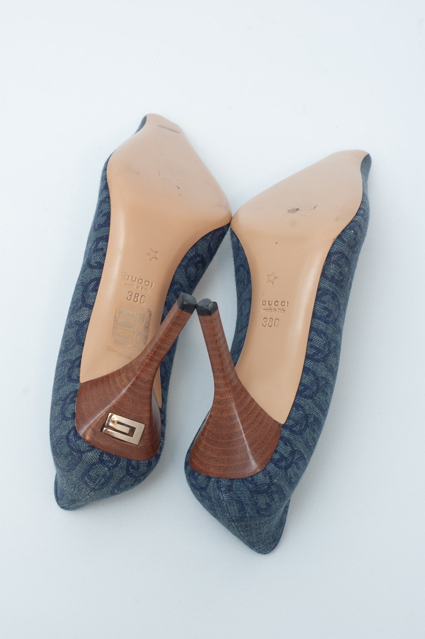 Pair of blue pointed-toe shoes with brown soles on a white background