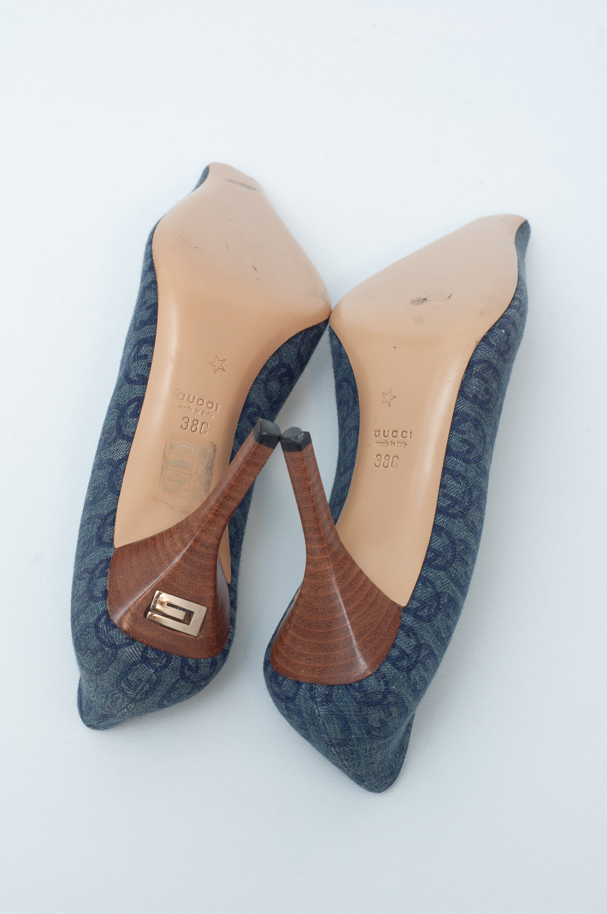 Pair of blue pointed-toe shoes with brown soles on a white background