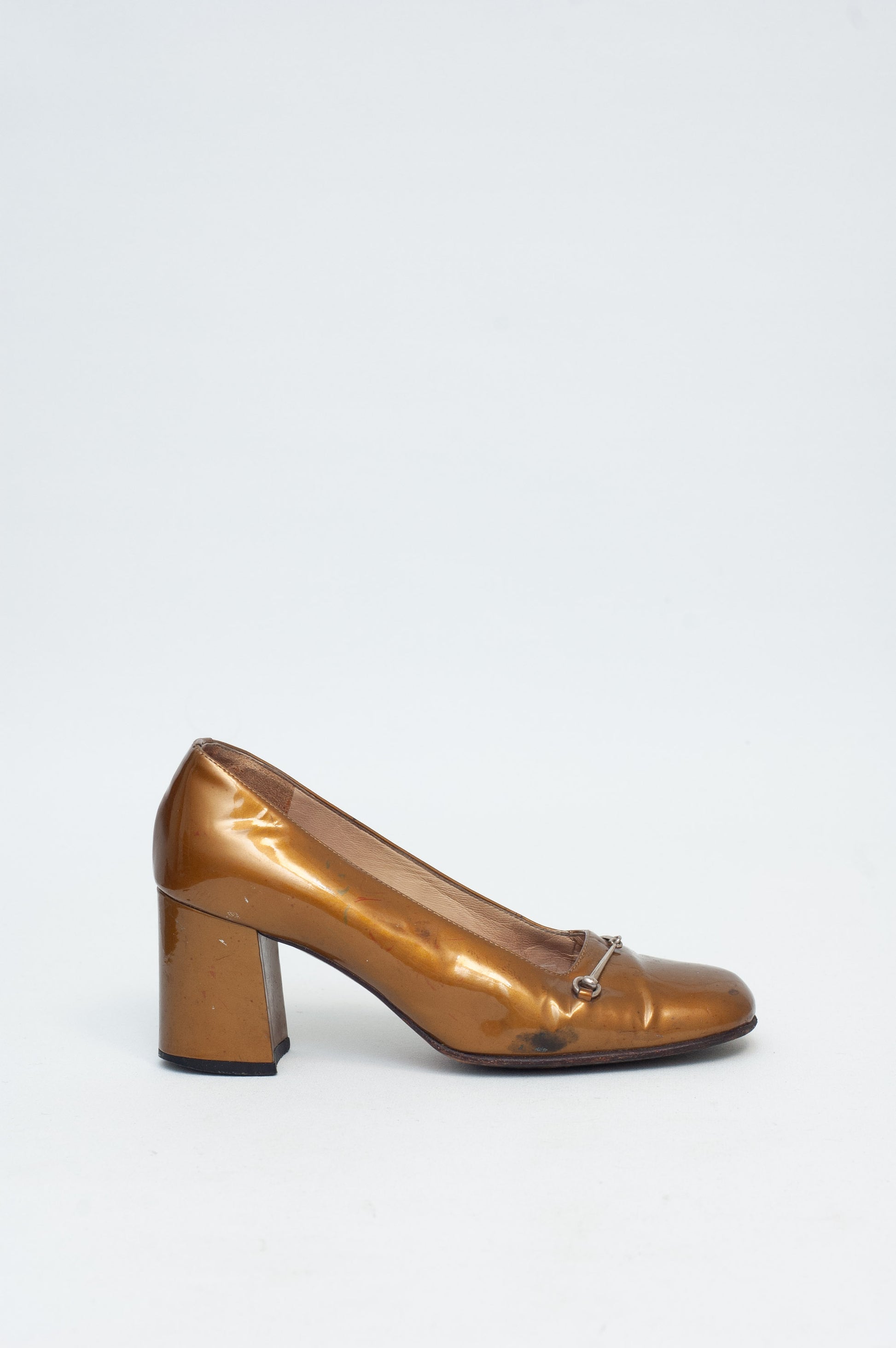 Bronze high-heeled shoe on a white background
