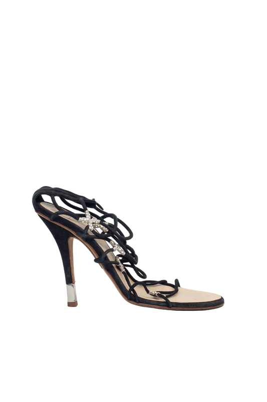 Black high-heeled sandal with intricate design on a white background
