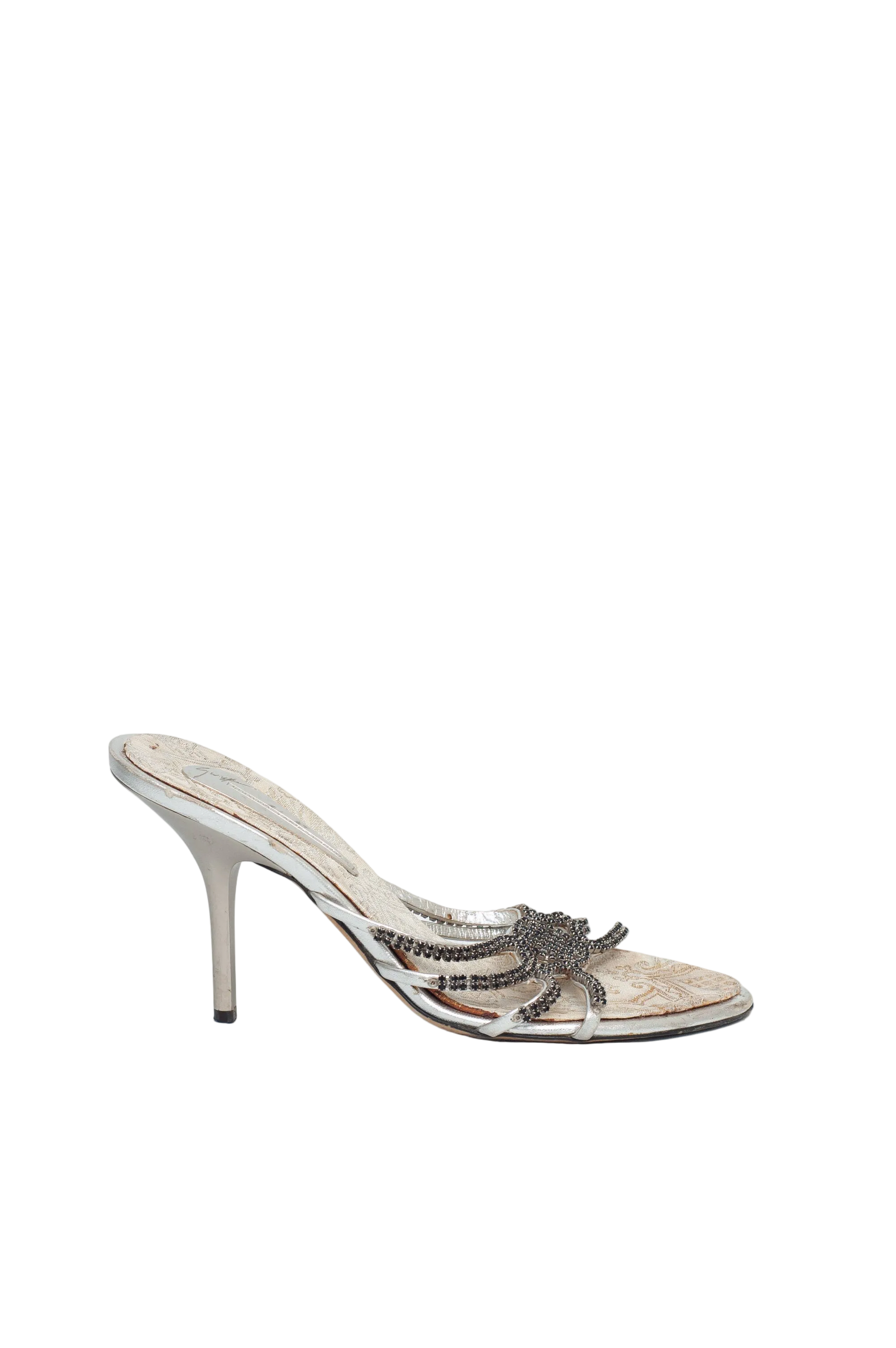 Silver high-heeled shoe with decorative design on a white background