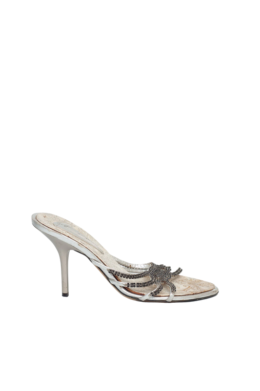 Silver high-heeled shoe with decorative design on a white background