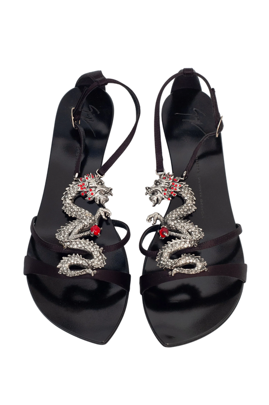 Black high-heeled sandals with snake designs on a white background