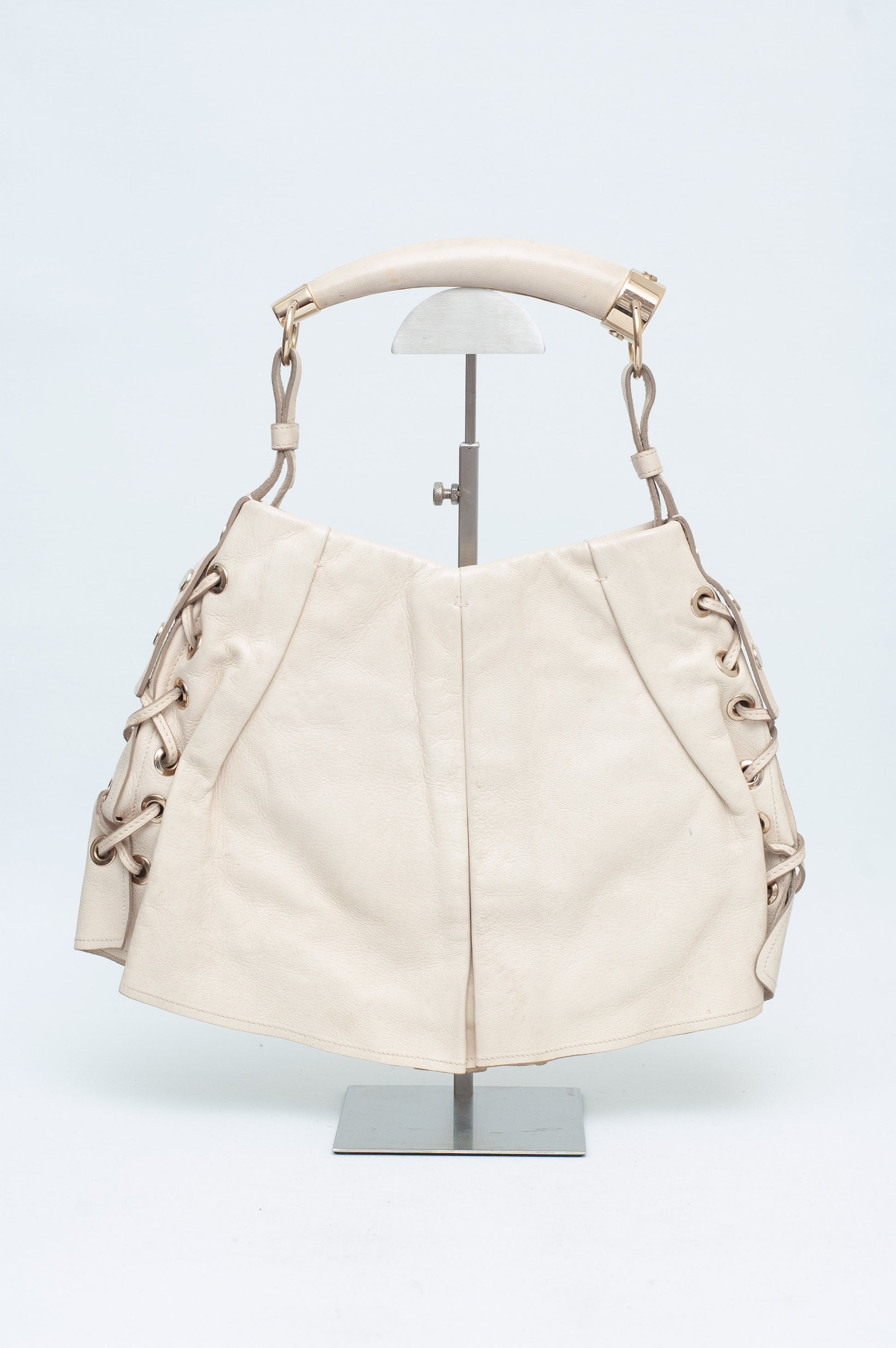 Beige handbag on a mannequin against a white background
