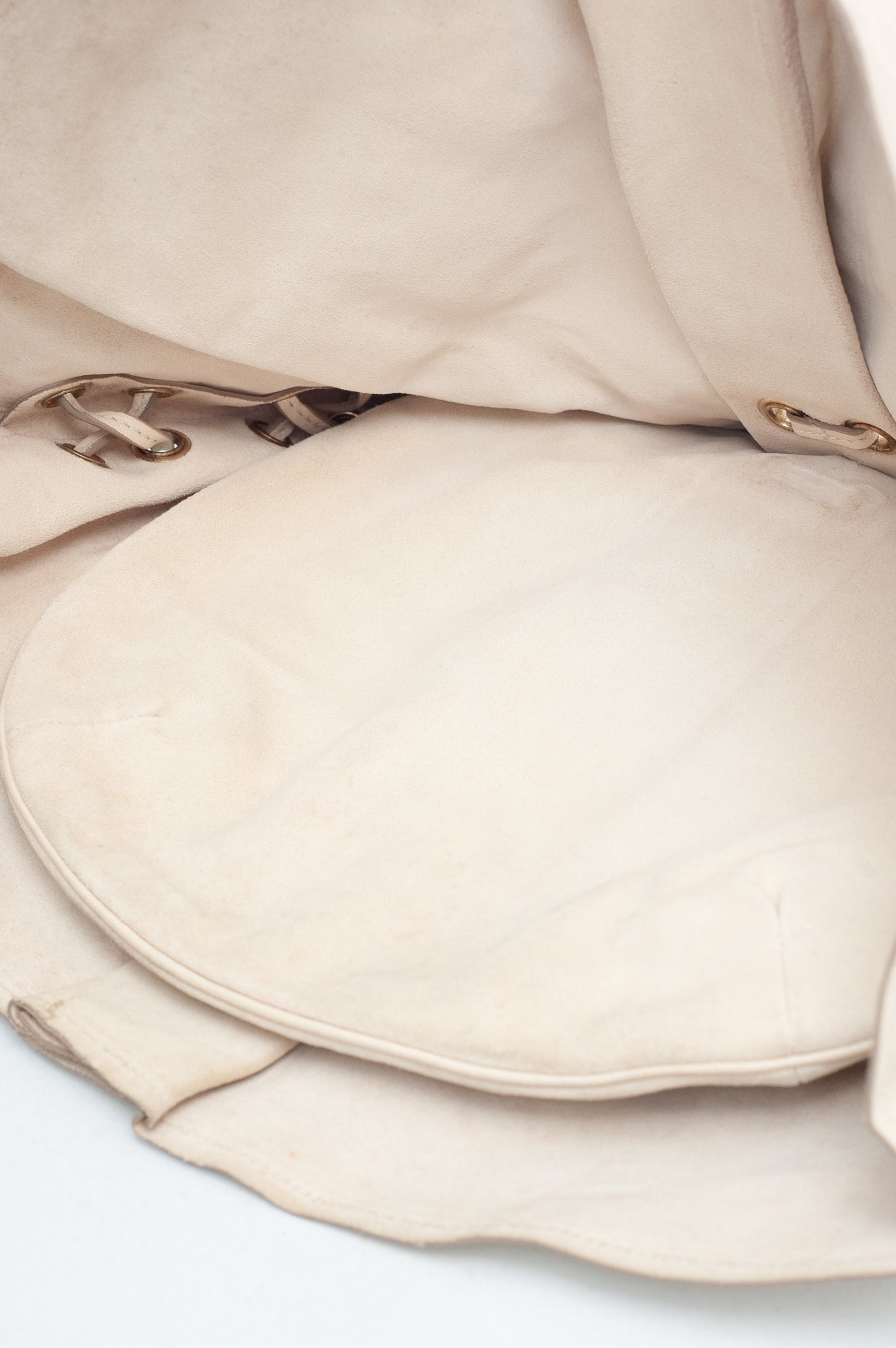Close-up of beige fabric with a textured pattern on a light background