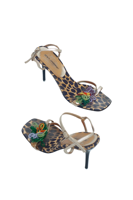 Pair of high-heeled shoes with leopard print and floral design on a white background