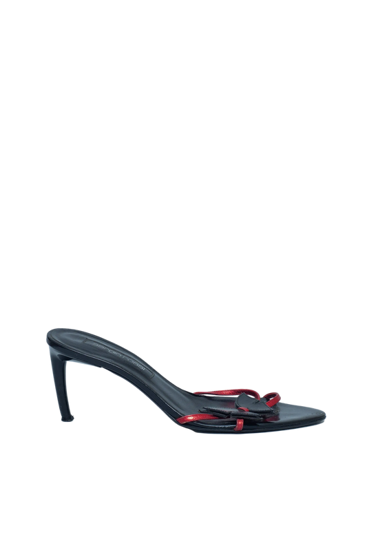 Black high-heeled sandal with red accents on a light gray background